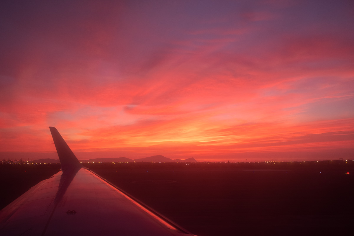 Bright pink sunset from the window seat of a plane in Lima